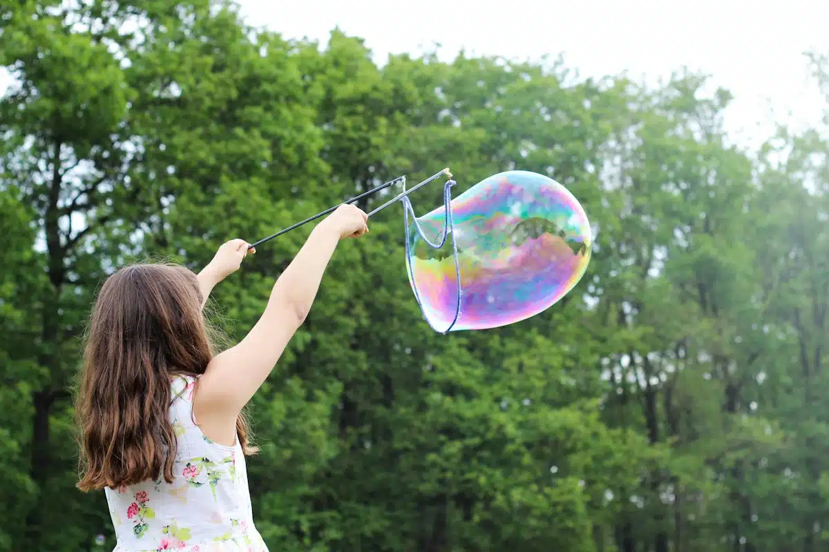 Enfant qui fait des bulles de savon en plein jour
