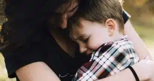 Adulte qui serre un enfant dans ses bras, image de l'enfant intérieur