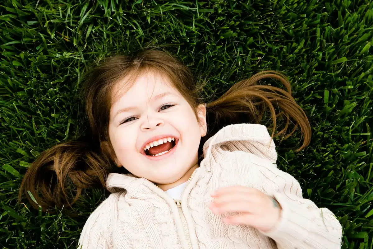 Enfant souriant allongé dans l'herbe